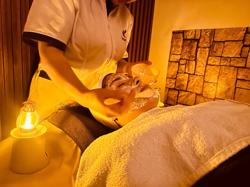 Terapeuta de Inito Spa aplicando un tratamiento facial con esponjas.