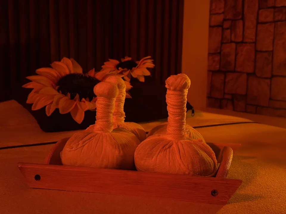 Pindas de tela sobre una bandeja de madera junto a flores en Inito Spa.